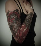 black and red flower arm sleeve tattoo by guy le tattooer