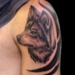 Black and brown wolf tattoo on arm