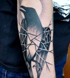 Black bird and moon tattoo on arm