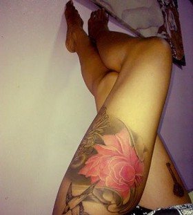 Black bird and pink flower tattoo on leg