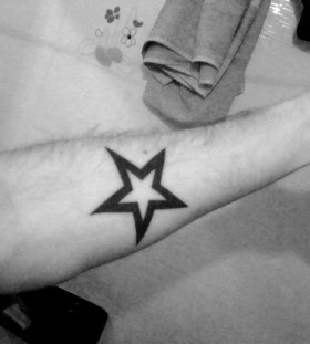 Black simple star tattoo on arm