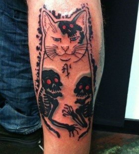 Black skull and cat tattoo on leg