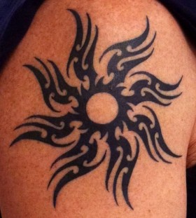 Black tribal sun tattoo on shoulder