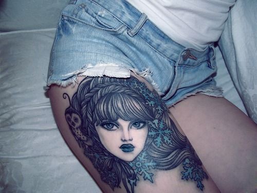 Blue women face tattoo on leg