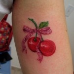 Cute red cherry tattoo on arm