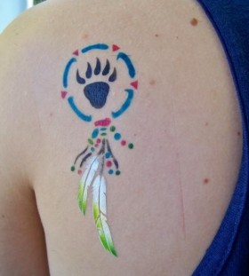 Feather and colorful black bear tattoo on shoulder