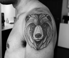 Gorgeous black ornaments of bear tattoo on shoulder