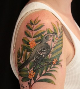 Green leaf and bird tattoo