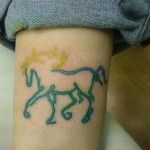 Green lovely horse tattoo on arm