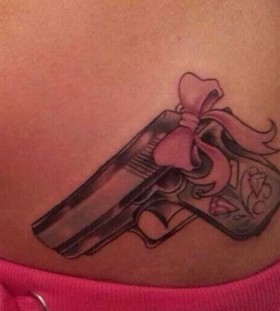 Pink bow and gun tattoo