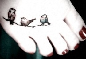 Red nails and black bird tattoo