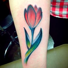 Red tulip tattoo on arm