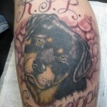 Sad black dog tattoo on arm