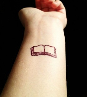 Small and pretty book tattoo on arm