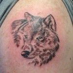 Small brown wolf tattoo on arm