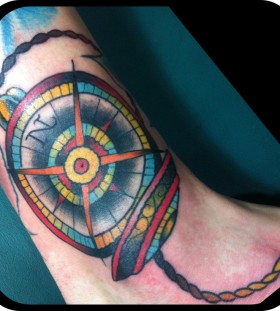 Colorful owals compass tattoo on leg