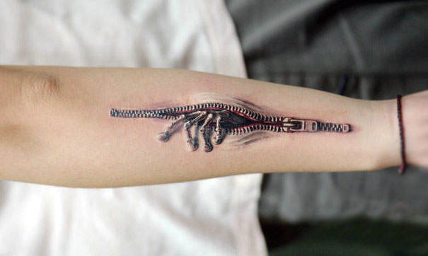 3D zipper effect with skeleton hand on arm tattoo