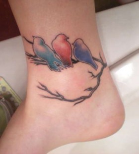 Colourful birds on a branch tattoo