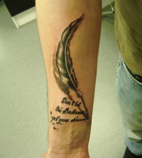 Feather pen and quote arm tattoo