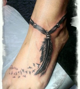Leg's feather and tribal bird tattoo