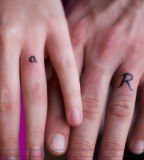 R and a Shaped Tattoo Design on Ring Finger