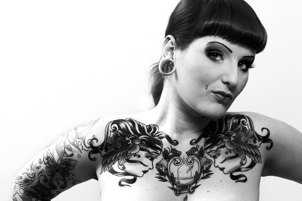 black and white photo girl with piercings chest tattoo
