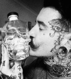 black and white photo man with scul face tattoo