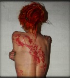 red ink tattoo red hair girl back tattoo