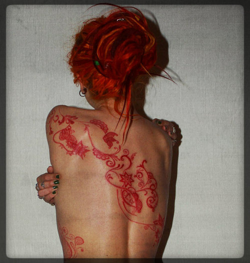 red ink tattoo red hair girl back tattoo