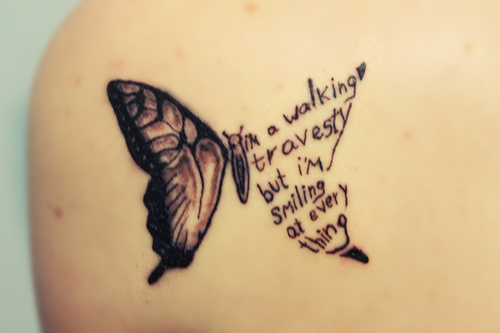 song lyric tattoo i’m a walking travesty but i’m smiling at every thing