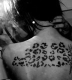black leopard print tatto on upper back