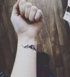 small mountain tattoo on arm