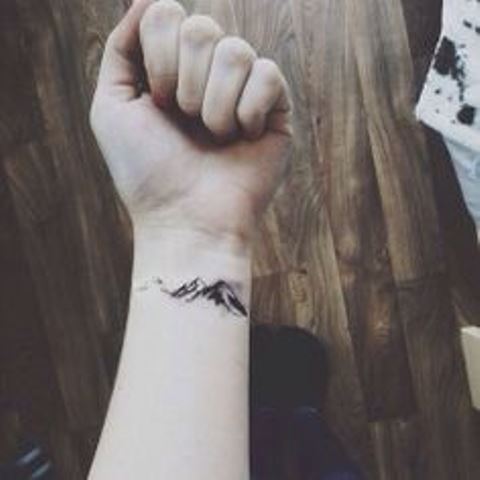 small mountain tattoo on arm
