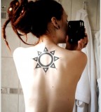 sun tattoo black work on upper back red hair