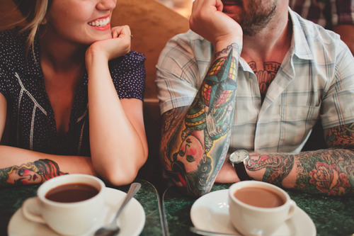 tattooed couple having coffee