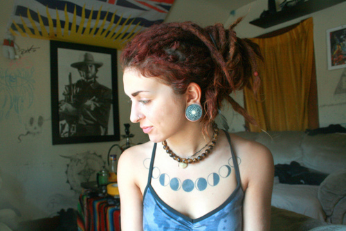 tattooed girl with dreadlocks blue moon phases on chest