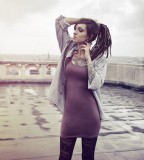 tattooed girl with dreadlocks grey sky chest and arm tattoos