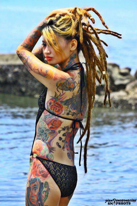 tattooed girl with dreadlocks in swimming suit