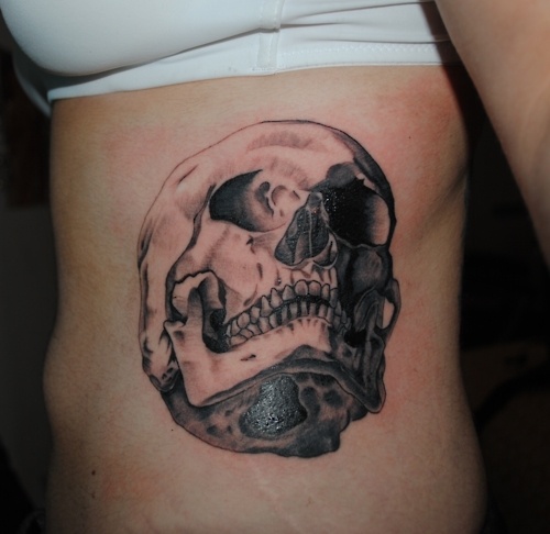 realistic scull on ribs tattoo