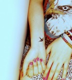 tiny black bird tattoo on wrist
