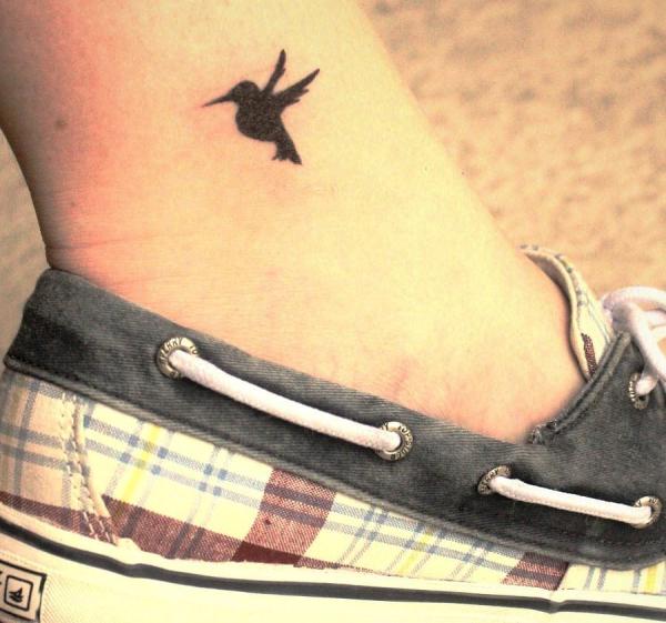tiny black hummingbird tattoo on leg