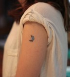 tiny boat tattoo on arm