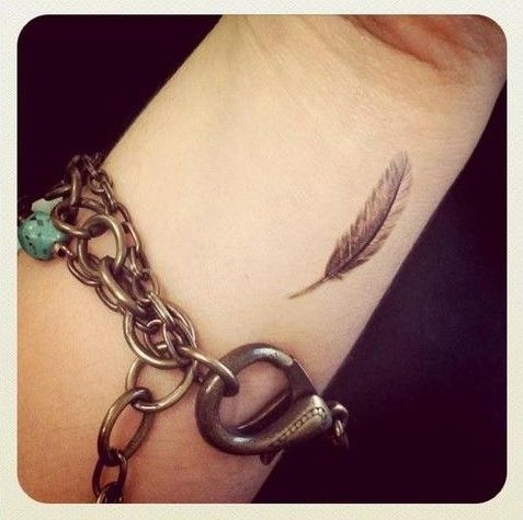 tiny feather tattoo on inside arm