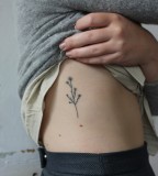 tiny wild flower tattoo on ribs