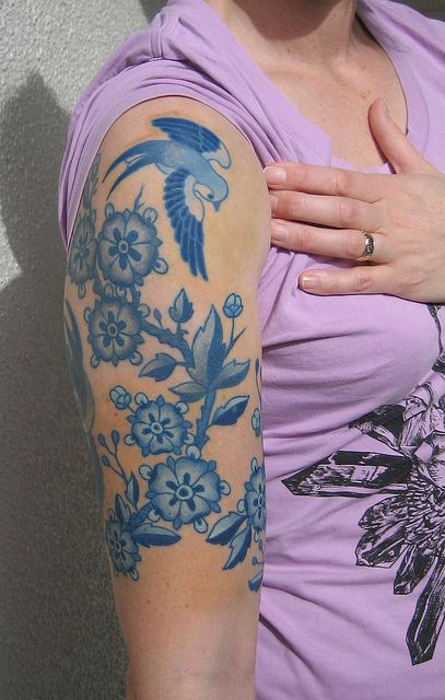 blue ink tattoo bird and flowers arm sleeve