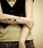 minimalist black floral arm tattoo