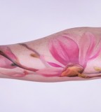 pastel watercolor flower tattoo on arm