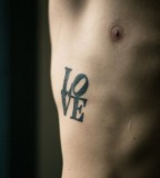 pop art tattoo typographic piece on ribs love