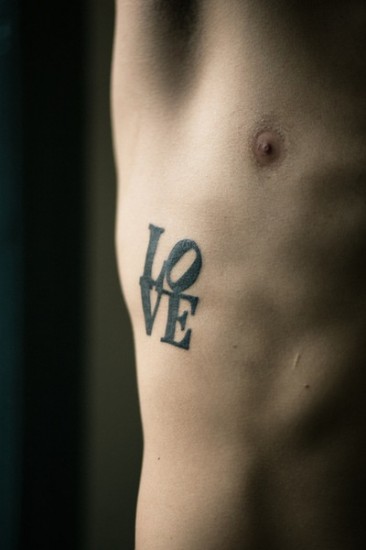 pop art tattoo typographic piece on ribs love