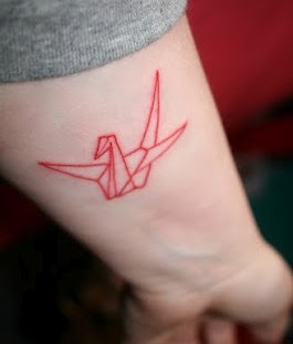 Red origami bird tattoo